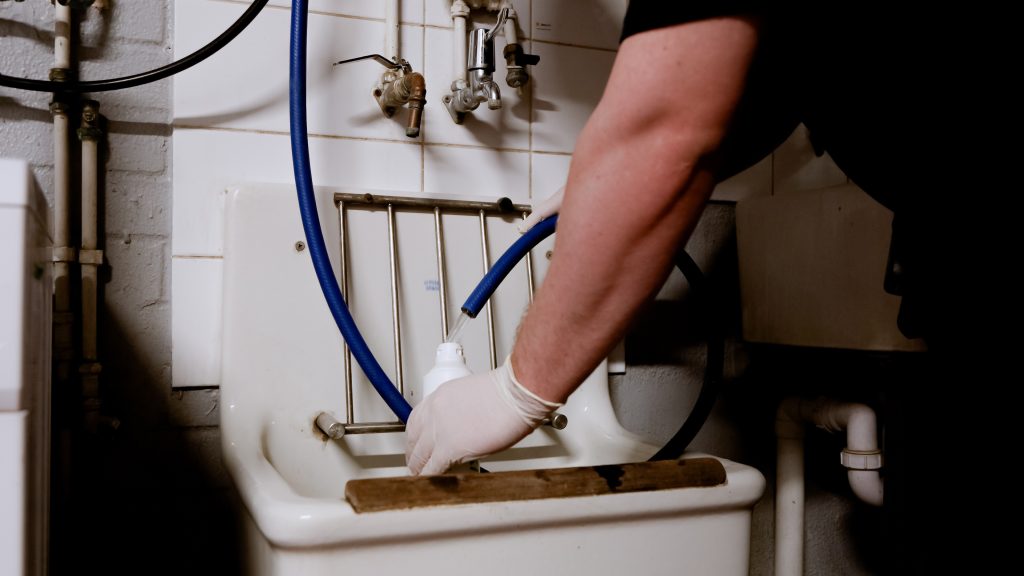 facilities managers cleaning sink with the Ozoklenz chemical-free solution